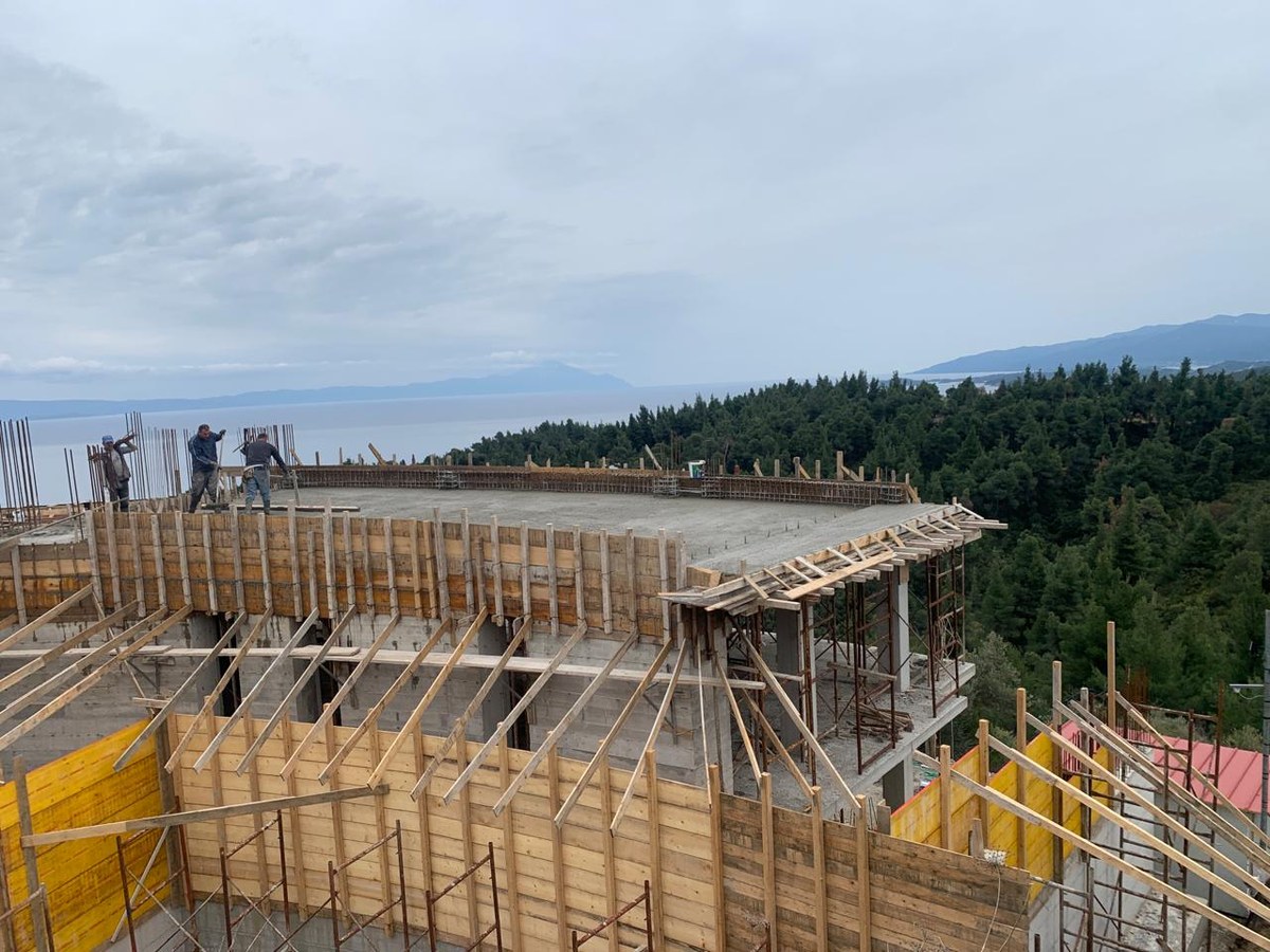 Akra Vista villa under construction — pouring an upper slab, the aegean beyond